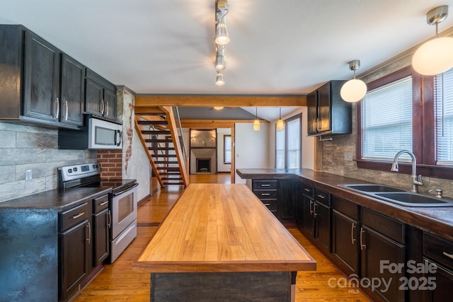 kitchen featuring tasteful backsplash, electric stove, wood counters, light wood-style floors, and a sink