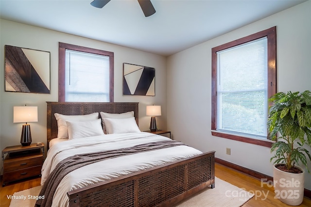 bedroom with ceiling fan, baseboards, and wood finished floors