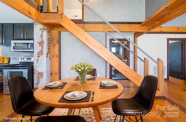 dining space featuring stairway and light wood-type flooring