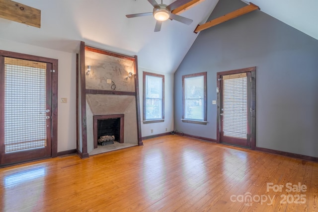 unfurnished living room featuring a ceiling fan, a fireplace, baseboards, and wood finished floors