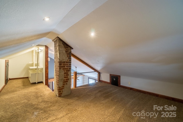 additional living space featuring carpet floors, baseboards, and vaulted ceiling