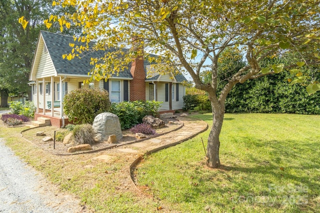 exterior space with roof with shingles, a chimney, and a front lawn