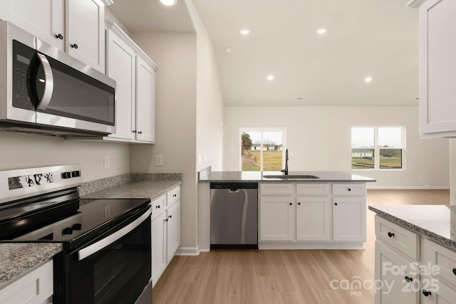 kitchen featuring appliances with stainless steel finishes, a sink, a wealth of natural light, and white cabinetry