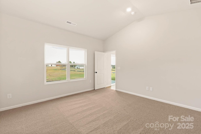 carpeted empty room with baseboards, visible vents, and vaulted ceiling