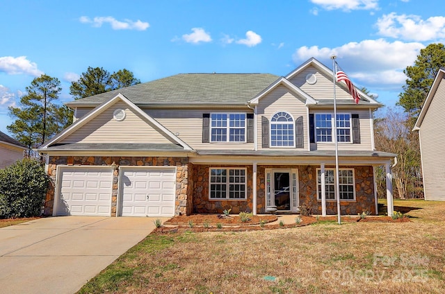 traditional home featuring a porch, a garage, stone siding, driveway, and a front lawn