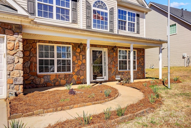 view of front facade with covered porch and stone siding