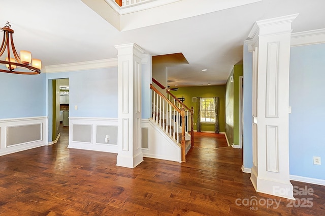 interior space featuring stairway, wood-type flooring, an inviting chandelier, and ornate columns