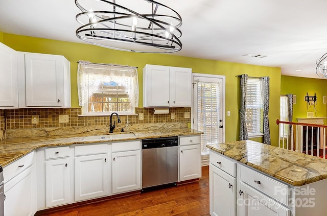 kitchen featuring decorative backsplash, stainless steel dishwasher, dark wood-type flooring, white cabinets, and a sink