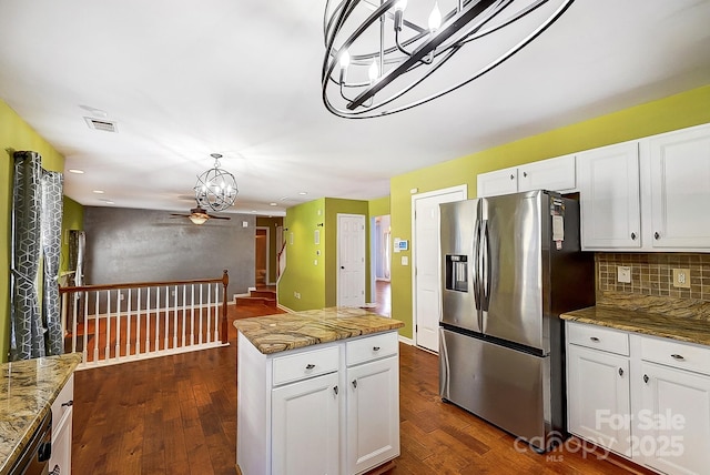 kitchen with light stone countertops, decorative backsplash, dark wood-type flooring, and stainless steel fridge with ice dispenser