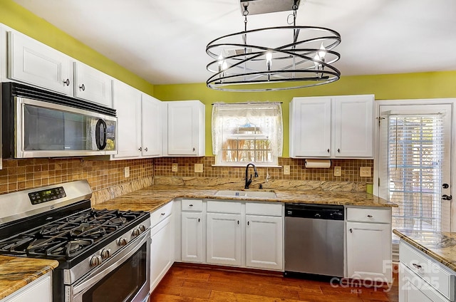 kitchen featuring decorative backsplash, dark wood-style floors, stainless steel appliances, white cabinetry, and a sink