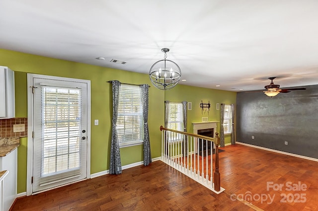 doorway to outside featuring baseboards, a fireplace, visible vents, and wood finished floors