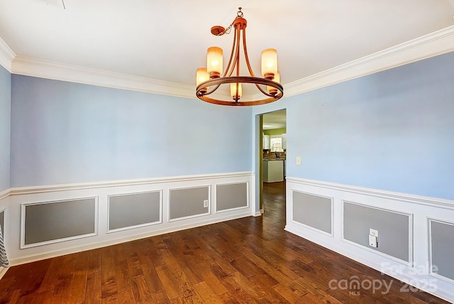 interior space featuring ornamental molding, wainscoting, a notable chandelier, and wood finished floors