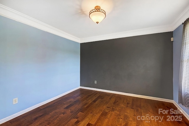 empty room with dark wood-style floors, baseboards, and crown molding