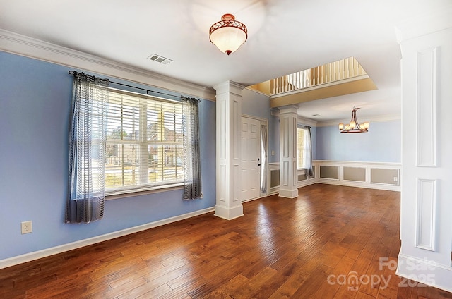 spare room featuring ornate columns, visible vents, hardwood / wood-style flooring, and ornamental molding