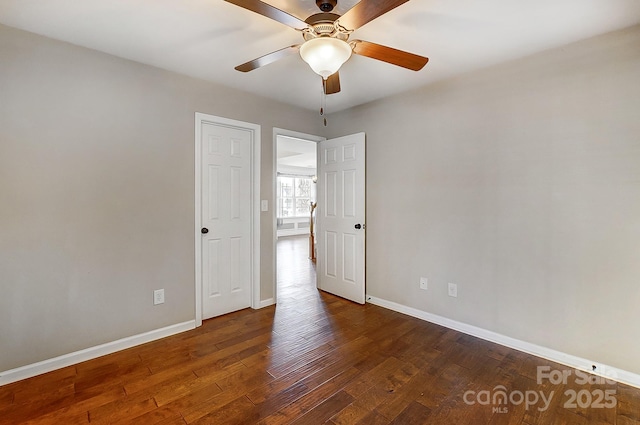 spare room featuring a ceiling fan, baseboards, and wood finished floors