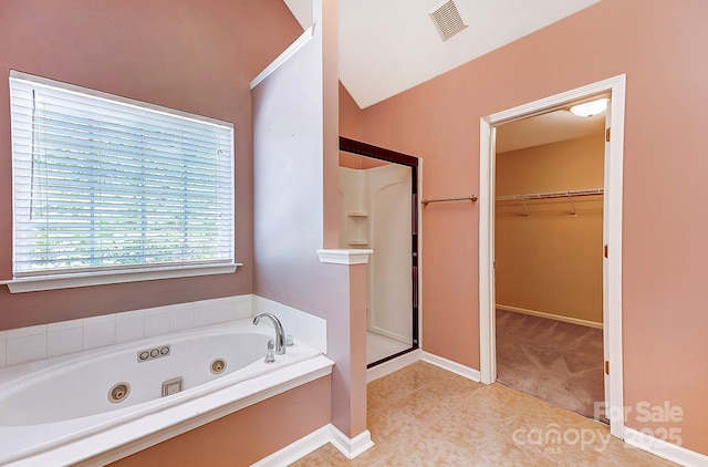 bathroom featuring visible vents, a spacious closet, a shower stall, baseboards, and a tub with jets