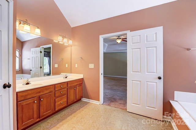 full bathroom with vaulted ceiling, double vanity, a sink, and a garden tub