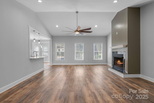 79 Mill Pond Way, Hendersonville, NC 28791 - unfurnished living room with dark wood finished floors, vaulted ceiling, baseboards, a ceiling fan, and a fireplace