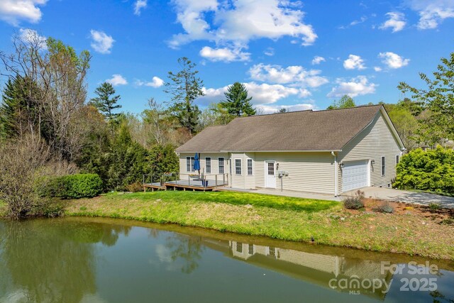 79 Mill Pond Way, Hendersonville, NC 28791 - rear view of property with a yard, a deck with water view, driveway, and an attached garage