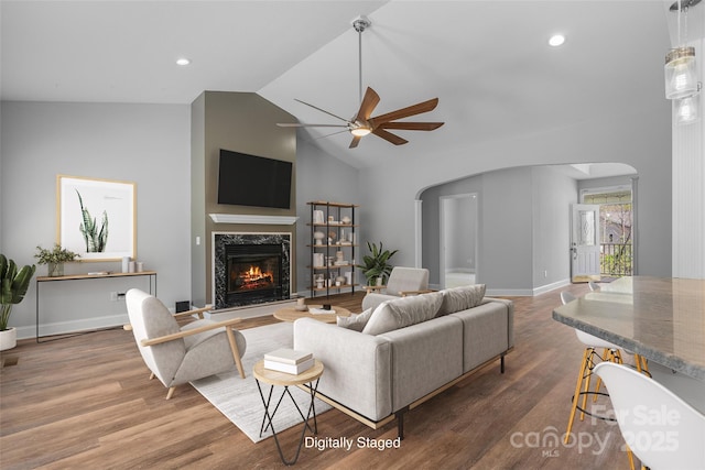 79 Mill Pond Way, Hendersonville, NC 28791 - living area featuring arched walkways, ceiling fan, lofted ceiling, a fireplace, and wood finished floors