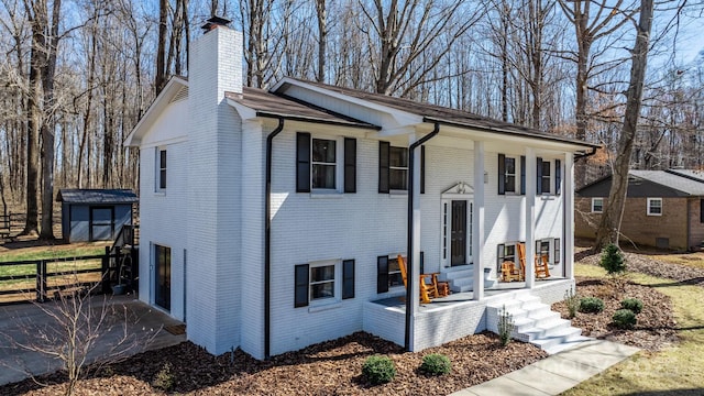 bi-level home featuring brick siding, fence, and a chimney