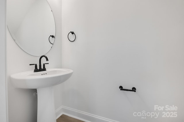 bathroom with a sink and baseboards