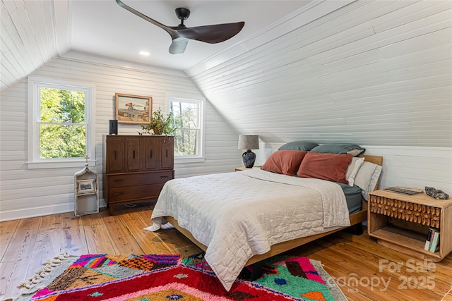 bedroom with multiple windows, light wood-type flooring, and lofted ceiling