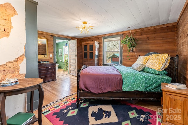 bedroom with wooden walls and wood finished floors