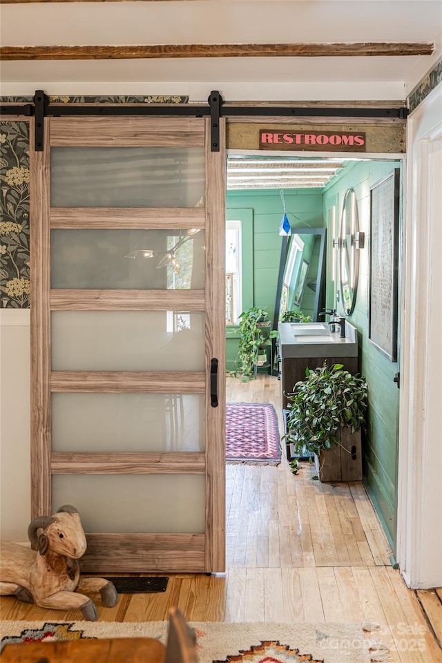 details featuring a barn door and wood finished floors