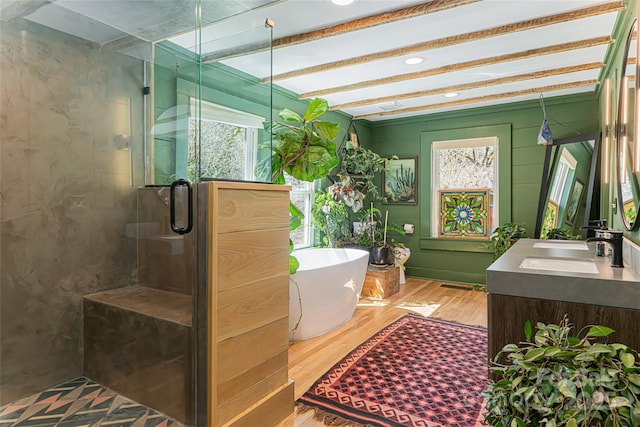 bathroom with a healthy amount of sunlight, a stall shower, a freestanding tub, and wood finished floors