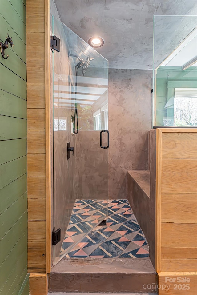 full bath with a shower stall and wooden walls