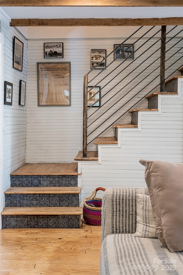 staircase with wood finished floors and wood walls