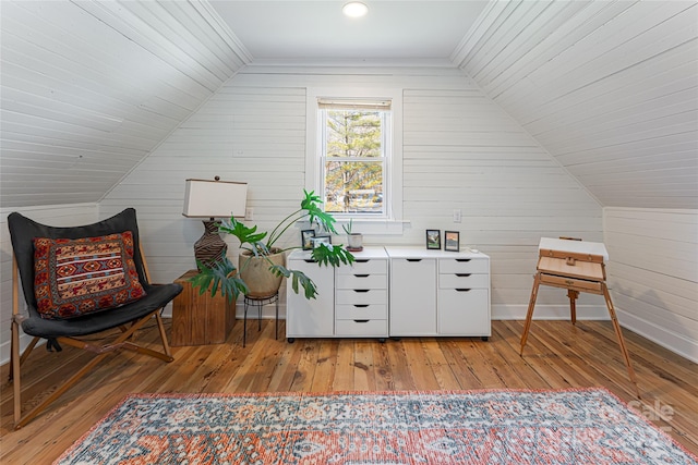 sitting room with lofted ceiling, baseboards, and light wood-type flooring