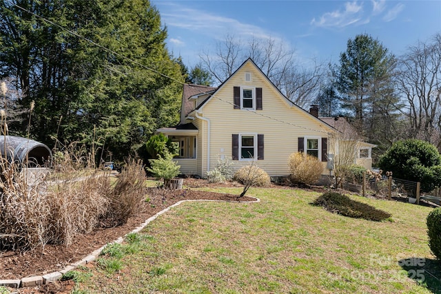 view of front of house with a chimney and a front yard