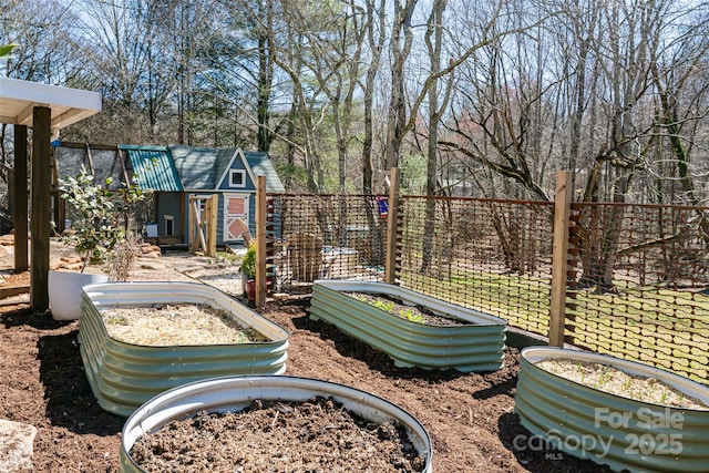 view of yard with a storage shed, an outdoor structure, a vegetable garden, and fence