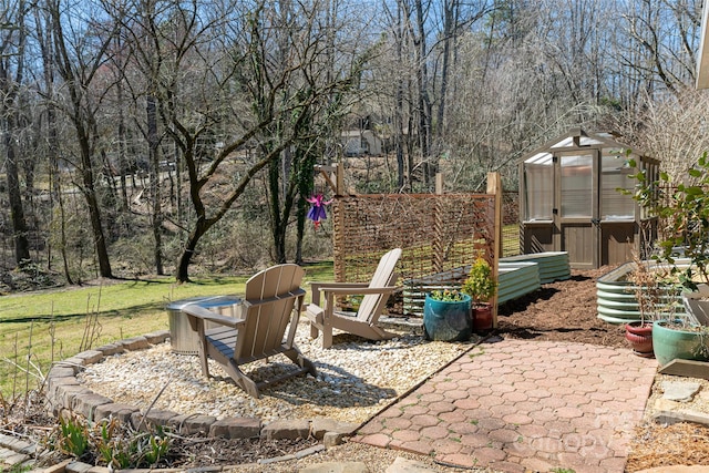 view of yard featuring a patio area, an outbuilding, fence, and an exterior structure