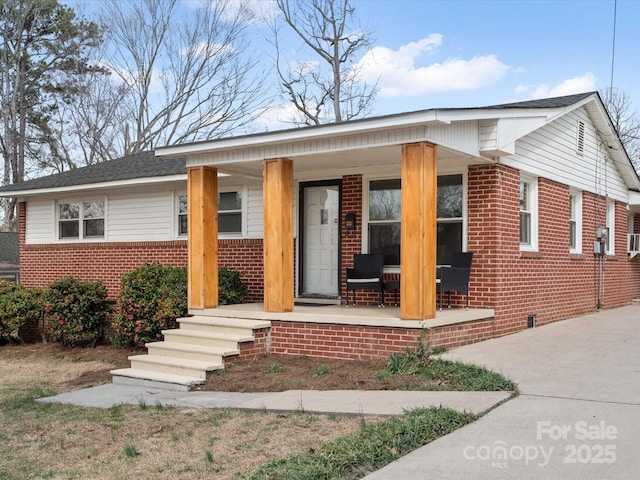 bungalow-style home with covered porch and brick siding