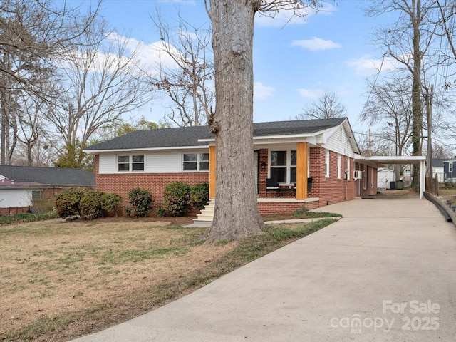 view of front facade with a carport, a porch, concrete driveway, and brick siding