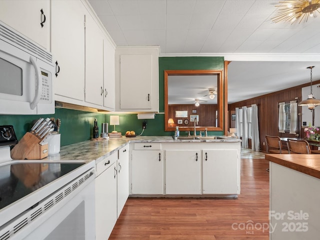 kitchen featuring white appliances, a sink, white cabinetry, and light wood-style floors