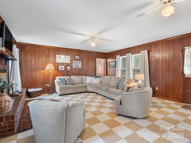 living area featuring ceiling fan, light floors, wood walls, and visible vents