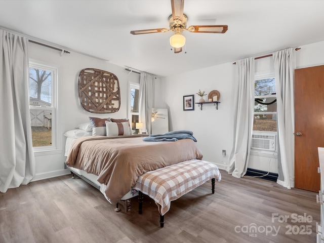 bedroom featuring cooling unit, wood finished floors, a ceiling fan, and baseboards