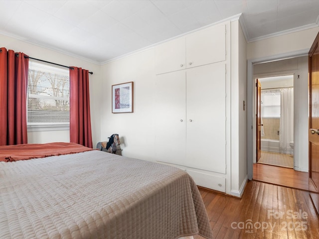 bedroom with hardwood / wood-style flooring, a closet, and crown molding