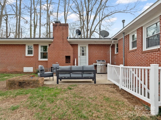 back of house featuring a patio area, an outdoor hangout area, and brick siding