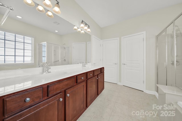 bathroom featuring a sink, a notable chandelier, a stall shower, and double vanity