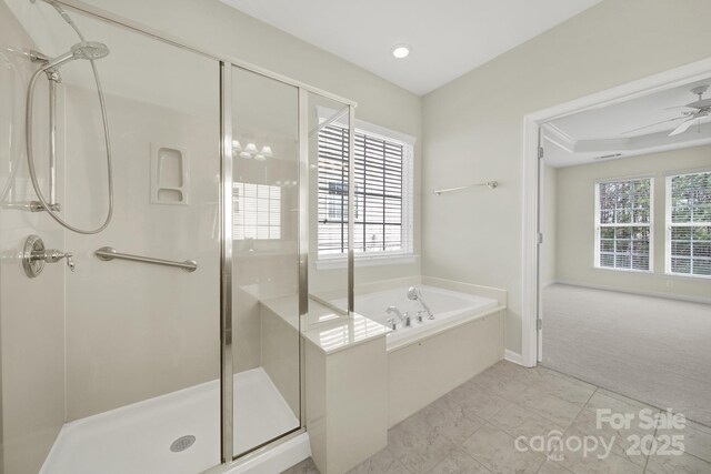 bathroom featuring plenty of natural light, a garden tub, and a shower stall