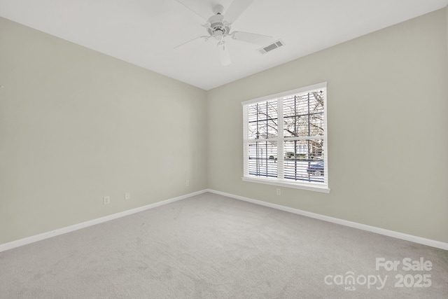 empty room with baseboards, carpet floors, visible vents, and ceiling fan