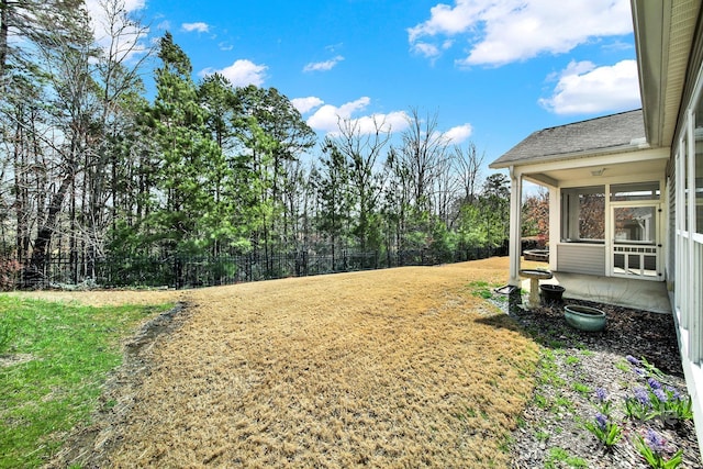 view of yard featuring a sunroom and fence