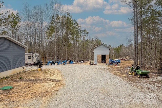 view of yard with an outbuilding and gravel driveway