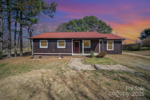 ranch-style house with a porch, a front yard, crawl space, and metal roof