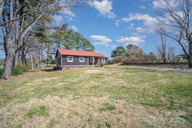 view of front of house featuring crawl space, metal roof, and a front lawn